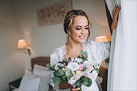 bride in white gown holding bouquet in elegant venue