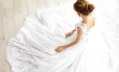 bride in elegant white wedding dress sitting on floor